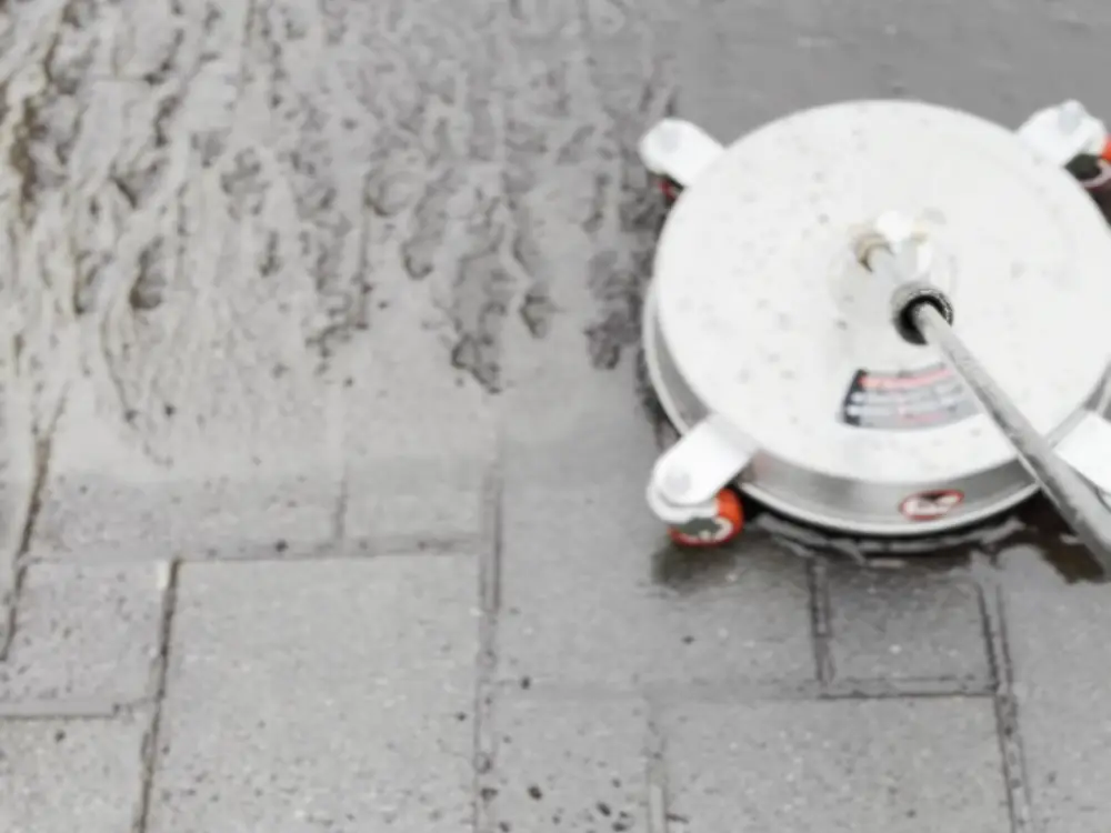 Surface cleaner cutting a clean line across paving stones